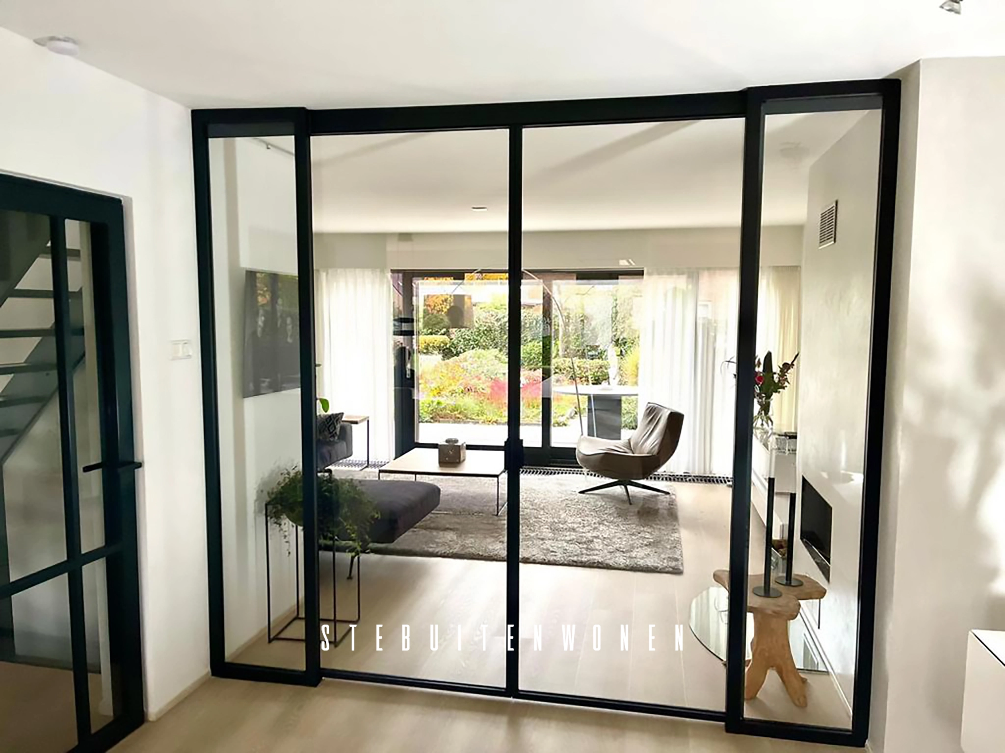 Moderne interieur met een stijlvolle glazen deur voorzien van softclose systeem, geflankeerd door twee vaste ramen, geïnstalleerd in een helder en minimalistisch ontwerp